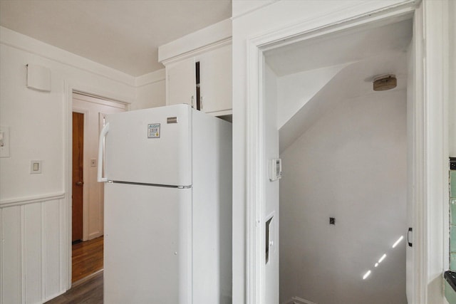 kitchen featuring wainscoting, freestanding refrigerator, and dark wood-style floors