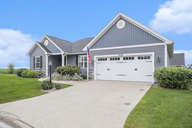 view of front facade featuring stone siding, concrete driveway, a garage, and a front lawn
