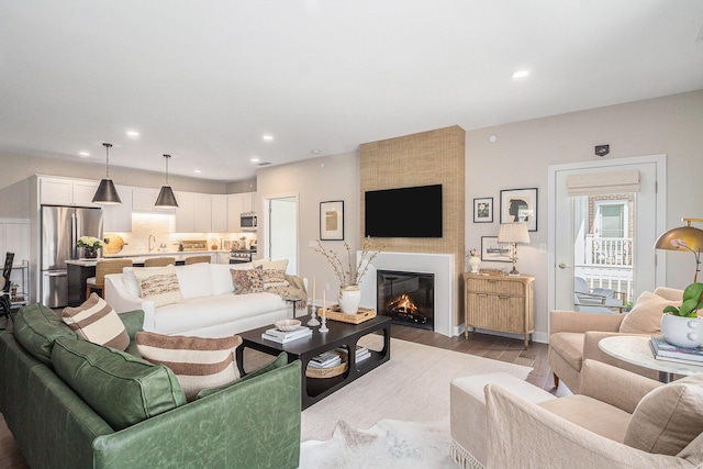 living room with a fireplace, recessed lighting, dark wood-style flooring, and baseboards