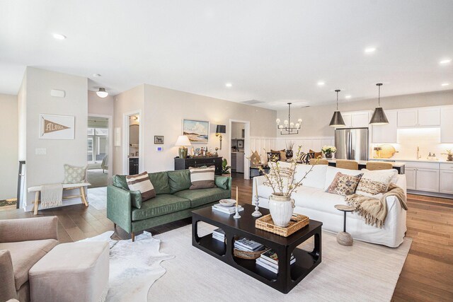 living area featuring recessed lighting, an inviting chandelier, and wood finished floors