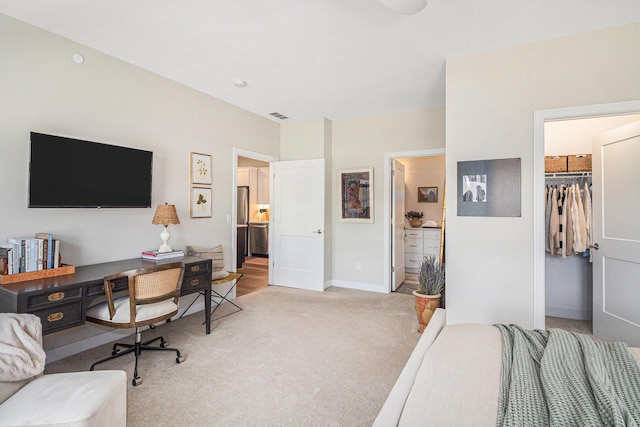 bedroom featuring visible vents, a closet, baseboards, a spacious closet, and light carpet