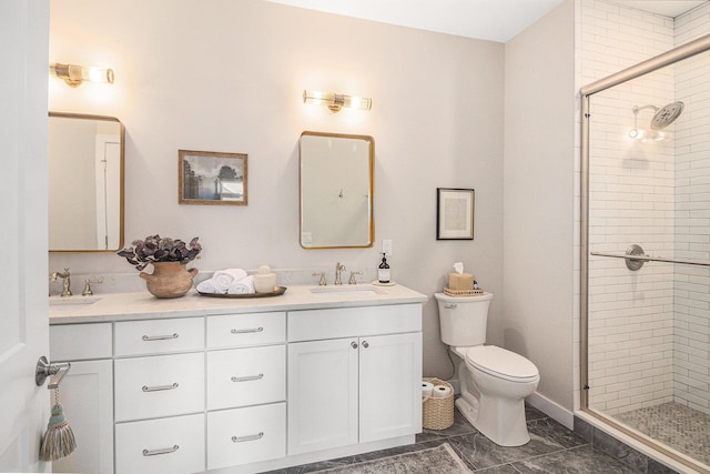 bathroom featuring toilet, a stall shower, double vanity, and a sink