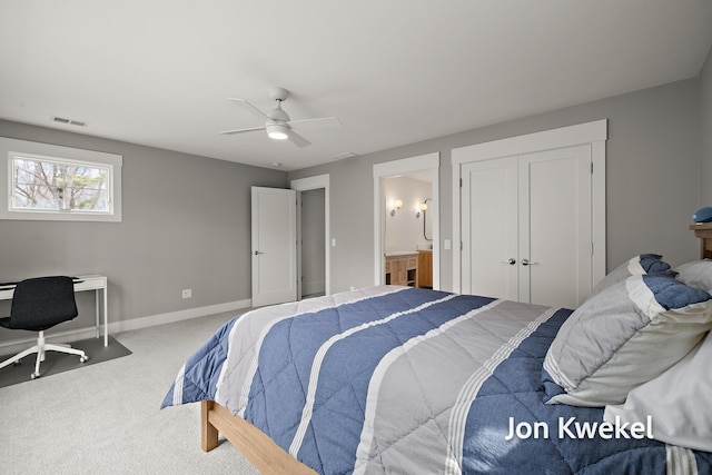 carpeted bedroom with ceiling fan, visible vents, baseboards, and ensuite bathroom