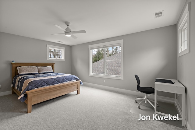 carpeted bedroom featuring baseboards, a ceiling fan, and visible vents