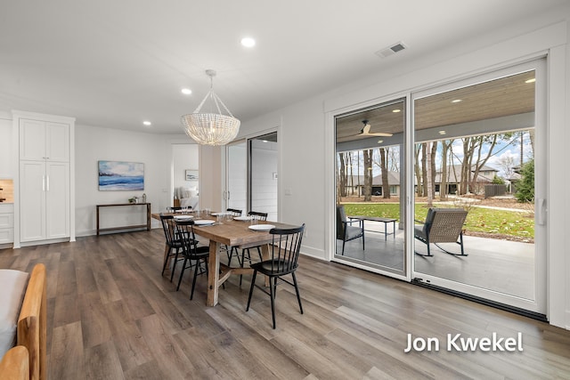 dining space with wood finished floors, a notable chandelier, and recessed lighting