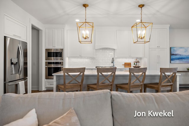 kitchen featuring a chandelier, white cabinets, decorative backsplash, and appliances with stainless steel finishes
