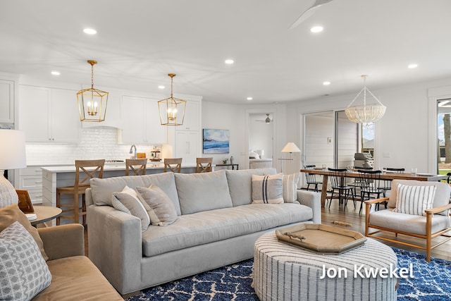 living room with recessed lighting, a chandelier, and wood finished floors
