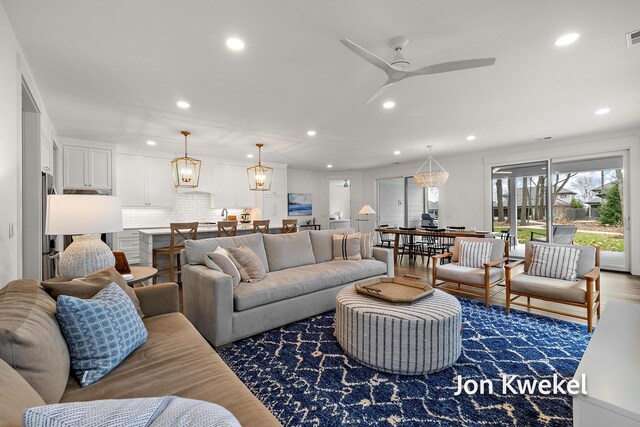 living area with visible vents, ceiling fan, recessed lighting, and wood finished floors