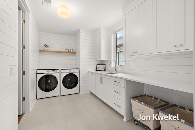 laundry room with a sink, visible vents, cabinet space, and washing machine and dryer