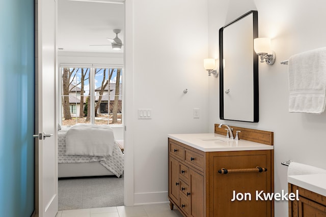 ensuite bathroom with ensuite bath, ceiling fan, vanity, and baseboards