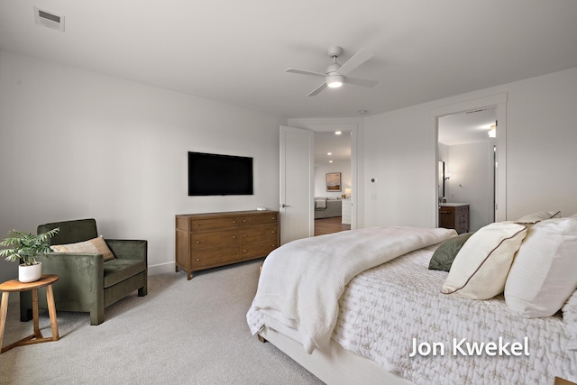 bedroom featuring light colored carpet, ceiling fan, ensuite bathroom, and visible vents