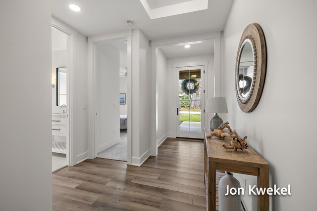 entryway featuring wood finished floors, baseboards, and recessed lighting