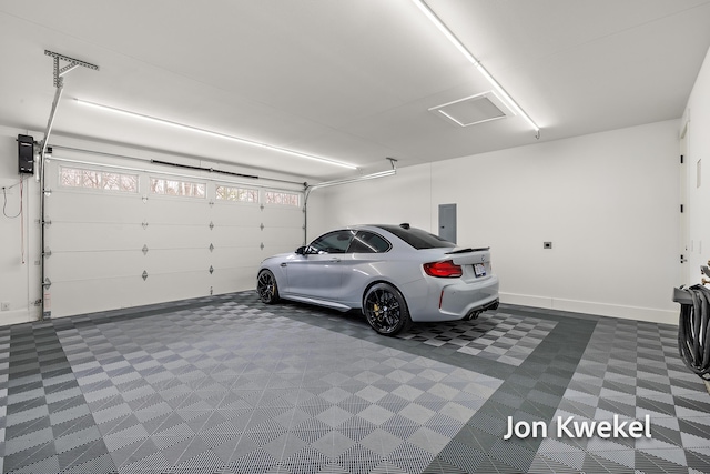 garage featuring baseboards and electric panel