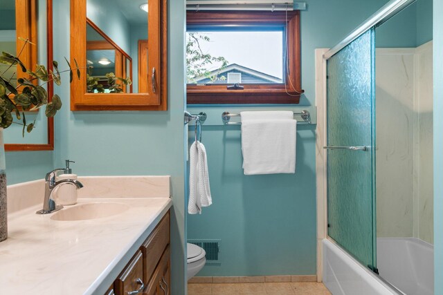 1569 Sheffield Dr, Ypsilanti, MI 48198 - full bathroom with tile patterned floors, toilet, vanity, and combined bath / shower with glass door