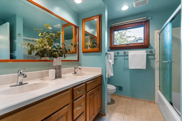 1569 Sheffield Dr, Ypsilanti, MI 48198 - full bath with toilet, double vanity, tile patterned flooring, baseboards, and combined bath / shower with glass door