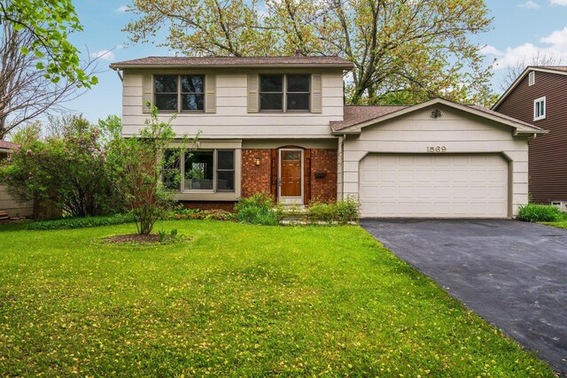 1569 Sheffield Dr, Ypsilanti, MI 48198 - colonial home featuring asphalt driveway, a garage, brick siding, a front lawn, and a shingled roof