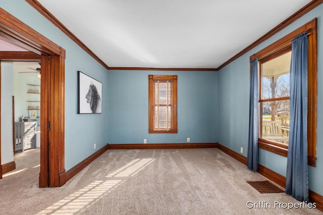 spare room featuring ornamental molding, baseboards, carpet, and visible vents
