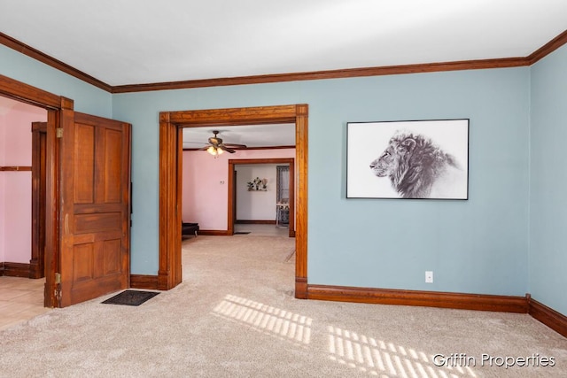 empty room featuring ornamental molding, carpet floors, and baseboards