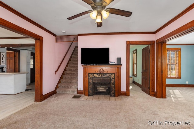 unfurnished living room featuring ornamental molding, carpet flooring, and stairs