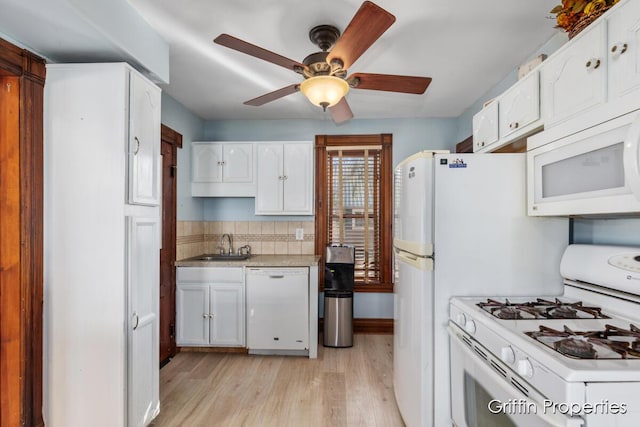 kitchen featuring a sink, light wood-type flooring, white appliances, a ceiling fan, and white cabinetry