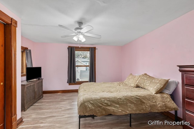 bedroom with baseboards, light wood-type flooring, and ceiling fan