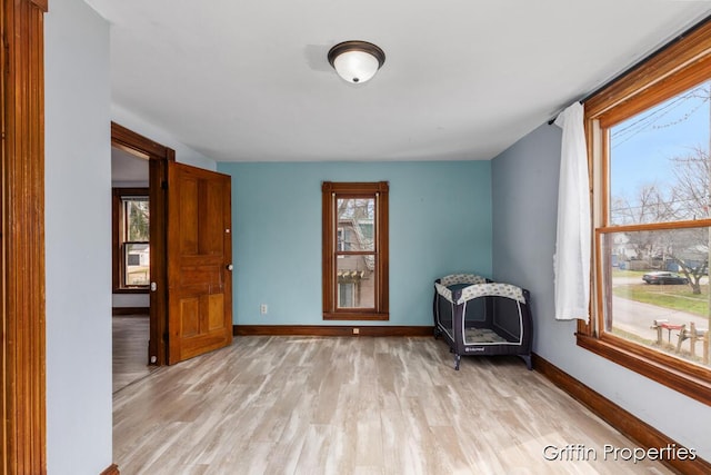 spare room featuring a wealth of natural light, light wood-style floors, and baseboards