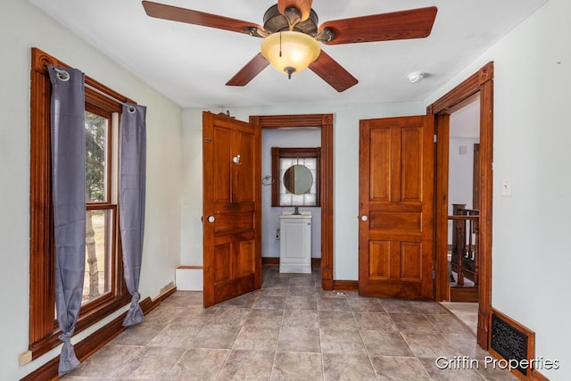 interior space featuring ceiling fan, baseboards, and visible vents