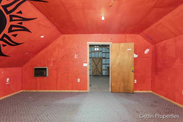 bonus room with a wall mounted air conditioner, carpet flooring, baseboards, and vaulted ceiling