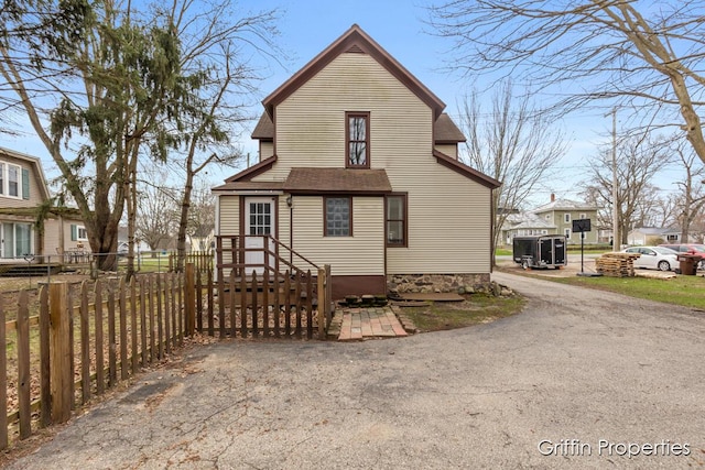 back of property with roof with shingles and fence