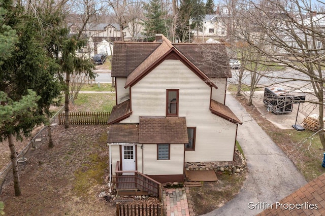 view of front of house with fence and a shingled roof