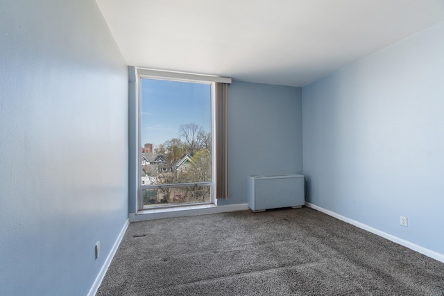 carpeted spare room featuring baseboards