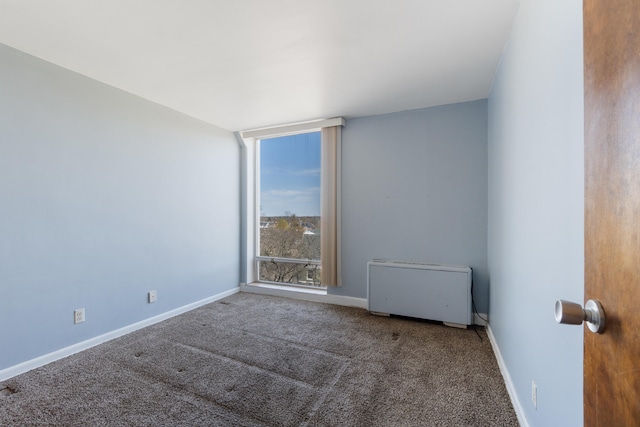 carpeted spare room featuring baseboards