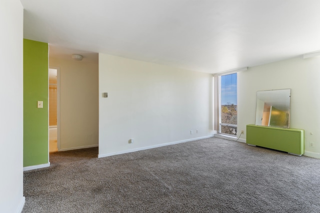 unfurnished living room featuring carpet floors and baseboards