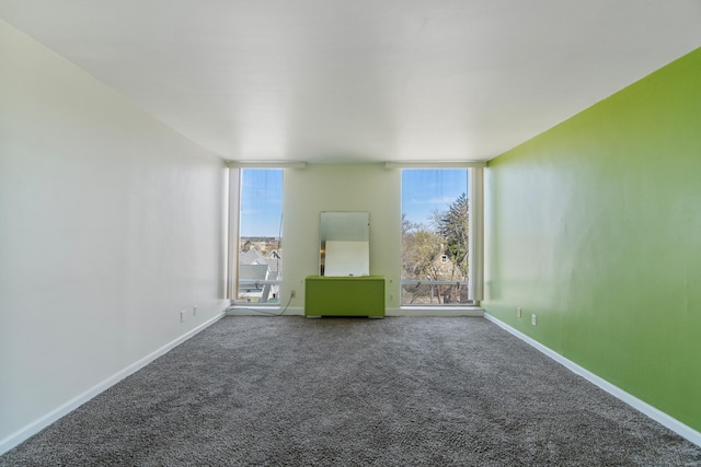 unfurnished room featuring carpet floors and baseboards