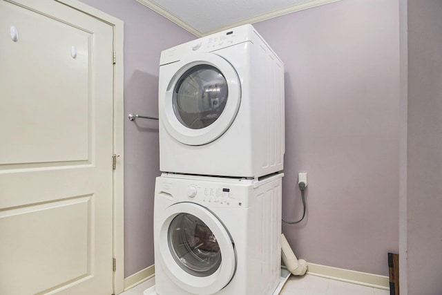 15330 Krueger St Unit 19, Spring Lake, MI 49456 - laundry room featuring crown molding, baseboards, stacked washer / dryer, and laundry area