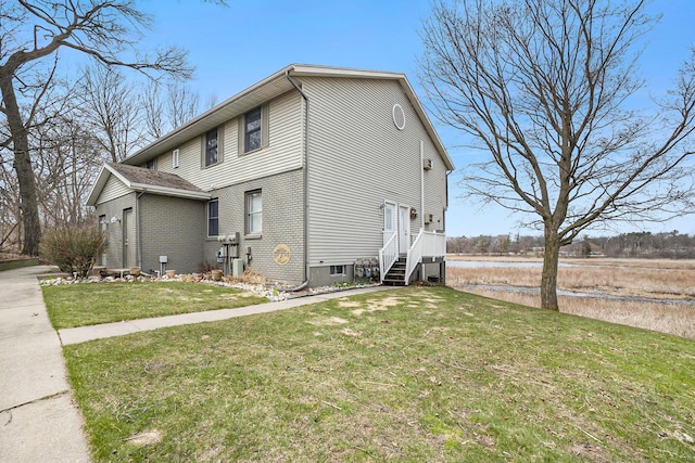 15330 Krueger St Unit 19, Spring Lake, MI 49456 - view of home's exterior with a yard, brick siding, and a water view