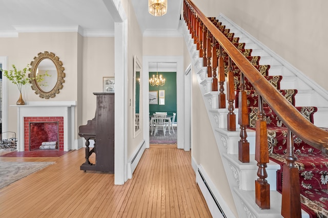 551 W Bridge St, Plainwell, MI 49080 - foyer entrance featuring crown molding, a notable chandelier, a baseboard heating unit, and stairs
