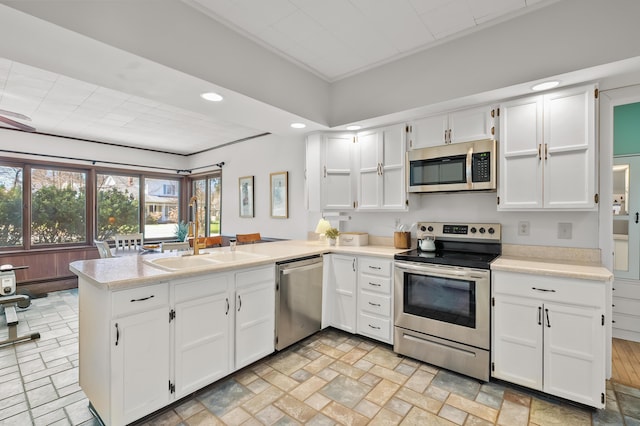 551 W Bridge St, Plainwell, MI 49080 - kitchen with a peninsula, white cabinetry, recessed lighting, light countertops, and stainless steel appliances