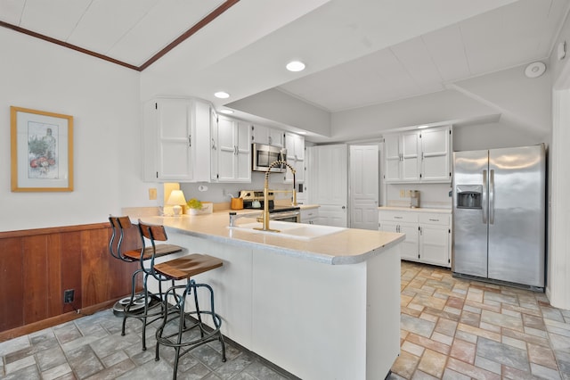 551 W Bridge St, Plainwell, MI 49080 - kitchen featuring light countertops, stone finish floor, a peninsula, and stainless steel appliances