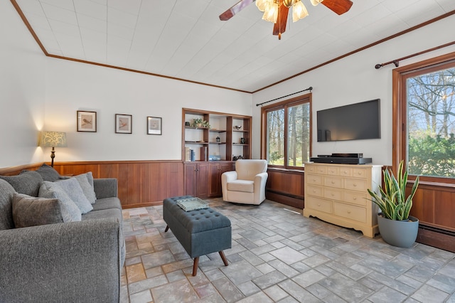 551 W Bridge St, Plainwell, MI 49080 - living area featuring crown molding, a baseboard heating unit, a ceiling fan, and stone tile flooring