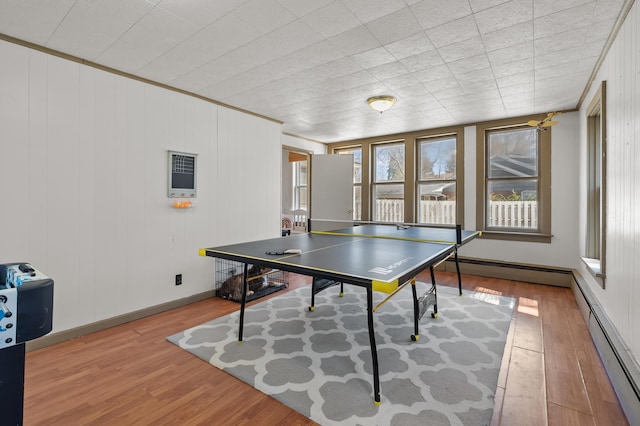 551 W Bridge St, Plainwell, MI 49080 - recreation room with baseboards, a baseboard radiator, crown molding, and wood finished floors