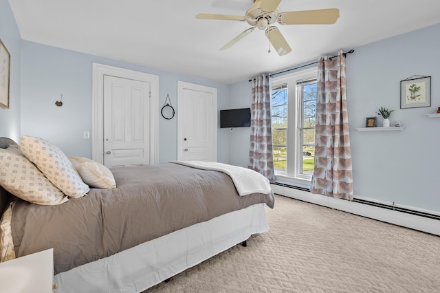 551 W Bridge St, Plainwell, MI 49080 - carpeted bedroom with a baseboard radiator, ceiling fan, and two closets