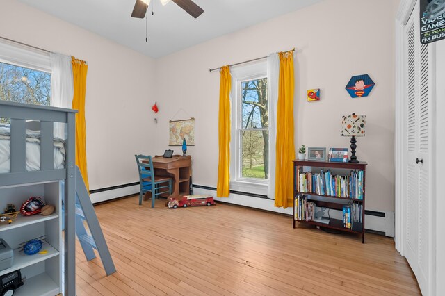 551 W Bridge St, Plainwell, MI 49080 - bedroom featuring a closet, a baseboard radiator, and wood finished floors