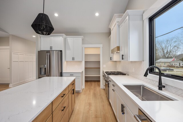 7701 Fase St SE Lot 15, Ada, MI 49301 - kitchen featuring a sink, light stone countertops, stainless steel appliances, and a wealth of natural light