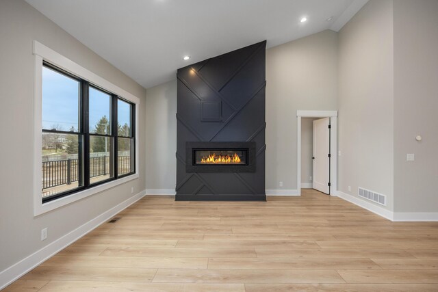 7701 Fase St SE Lot 15, Ada, MI 49301 - unfurnished living room featuring light wood-style floors, visible vents, baseboards, and a fireplace