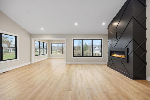 7701 Fase St SE Lot 15, Ada, MI 49301 - unfurnished living room featuring visible vents, light wood-style floors, baseboards, recessed lighting, and a large fireplace