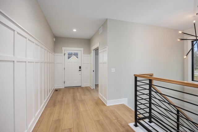 7701 Fase St SE Lot 15, Ada, MI 49301 - corridor with a notable chandelier, baseboards, an upstairs landing, light wood-type flooring, and visible vents