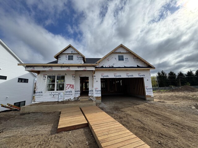 7701 Fase St SE Lot 15, Ada, MI 49301 - property under construction featuring fence, a porch, an attached garage, and driveway