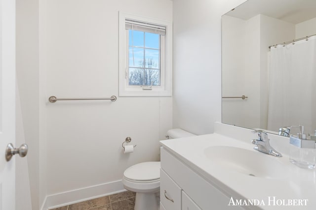 bathroom with tile patterned floors, toilet, vanity, and baseboards