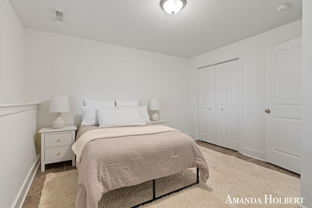 bedroom featuring a closet, baseboards, and visible vents